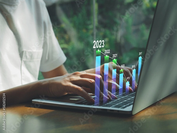 Fototapeta Positive indicators 2023, businessman calculating financial data for long-term investments in the coming year