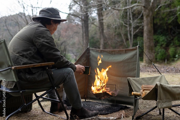 Fototapeta ソロキャンプで焚き火をする男性