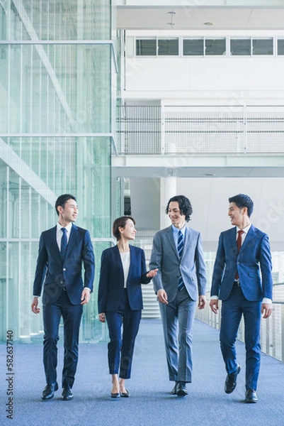Obraz オフィスの廊下を歩くビジネスマンの男女