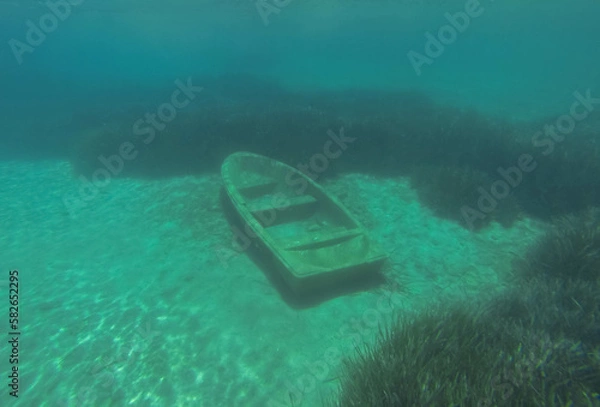 Obraz An old rowing boat is abandoned on the sandy bottom under the water.