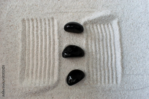 Obraz black stone in sand 