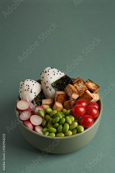 Fototapeta vegan bowl  with onigiri on teal color background