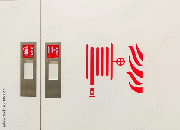 Fototapeta Fire hoses packed inside of red emergency box at the wall