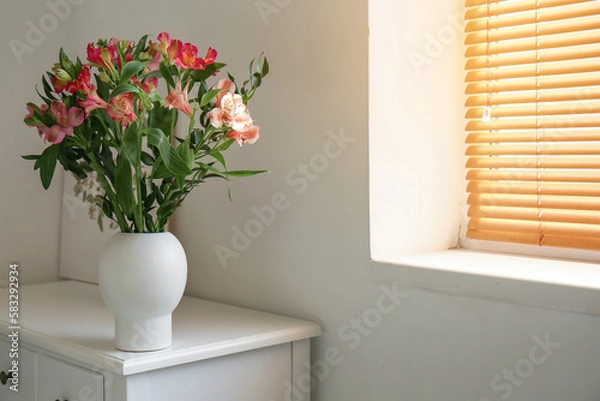 Fototapeta Vase with beautiful alstroemeria flowers on chair near light wall