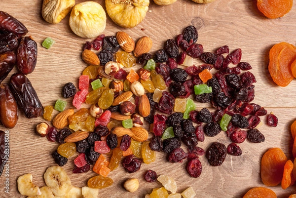 Fototapeta Dried fruits and nuts on wooden background. Healthy food. Fresh raw nuts and fruits