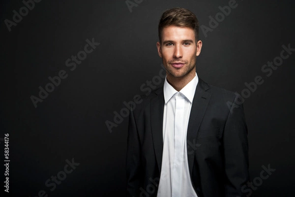 Obraz Businessman standing on dark gradient background