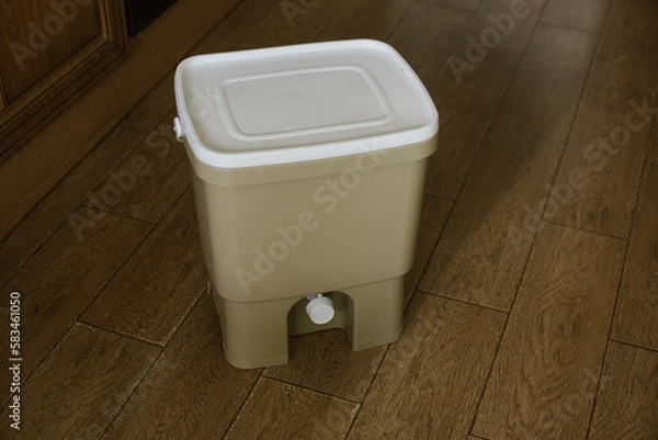 Fototapeta Trash bin for composting from kitchen at home on the floor. Copy space. Recycling organic scarps concept. Sustainable, ecology, zero waste lifestyle