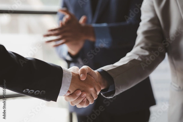 Fototapeta Close-up two business men holding hands, Two businessmen are agreeing on business together and shaking hands after a successful negotiation. Handshaking is a Western greeting or congratulation.
