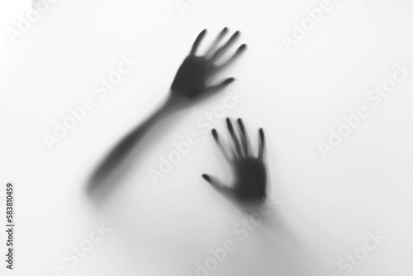 Fototapeta Defocused hand silhouette behind frosted glass in black and white mode, halloween concept