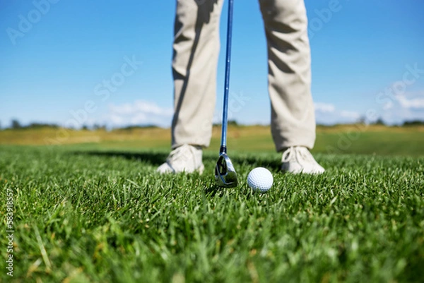 Fototapeta Low section of unrecognizable man playing golf on green grass, focus on ball, copy space
