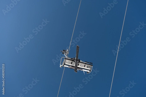 Fototapeta Vertical shot of  cableway cabin with a skier