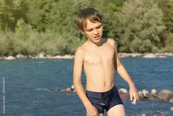 Obraz The boy is unhappy. He was splashed with water. Rest on the river bank