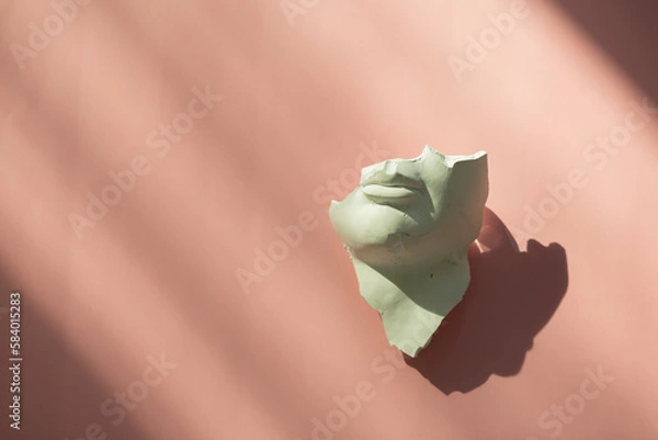 Fototapeta A fragment of an antique sculpture, a piece of a face on a pink background