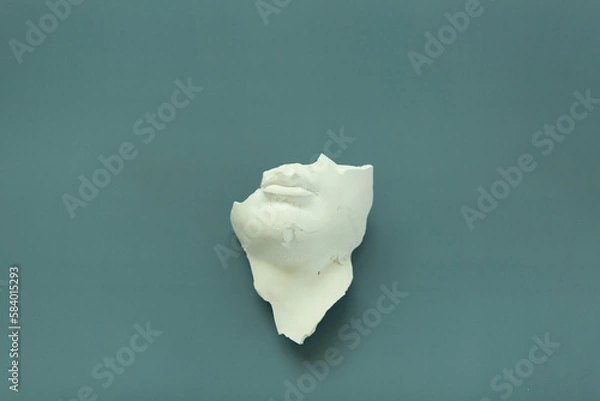 Fototapeta A fragment of an antique sculpture, a piece of a face on a blue background