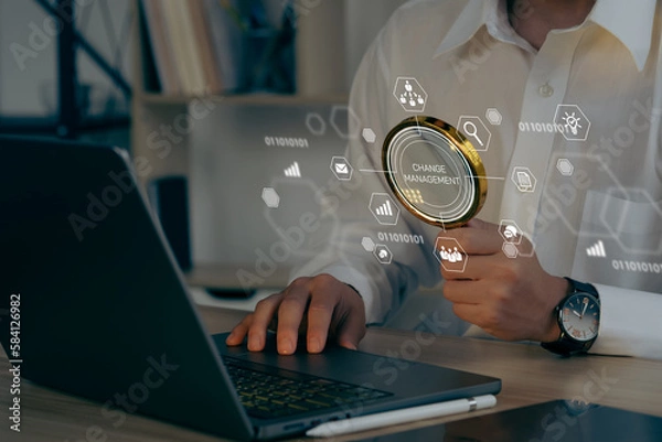 Obraz Businessman using a computer to document Change management in organization and business concept with consultant presenting icons of strategy. Organizational transition and transformation.