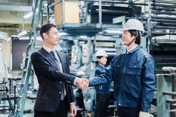 Fototapeta 取引先と握手をする工場のスタッフ