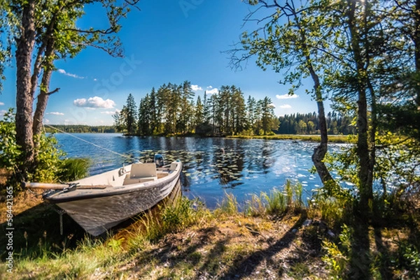 Fototapeta Summer day at a lake with a boat in Sweden