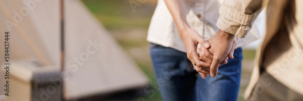 Fototapeta Asian couple camping outdoors. Couple travelers holding hands together love and Travel Lifestyle.