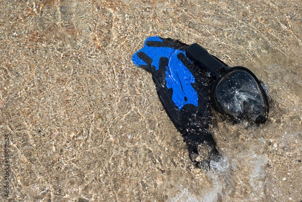 Fototapeta Fins for swimming and a mask for snorkeling on the beach. Wave and sand. Marine entertainment. Rest.