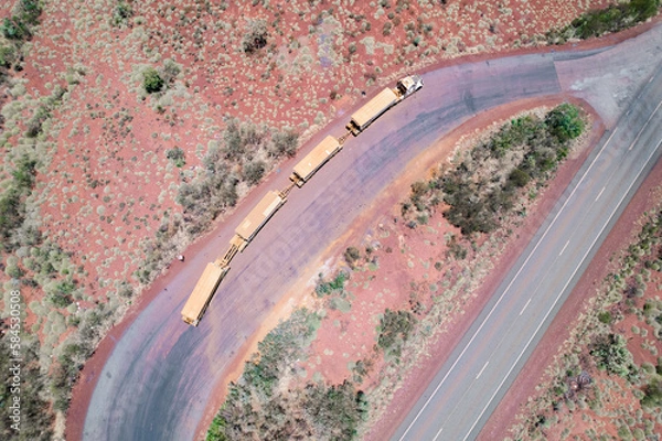 Obraz Looking down on a long truck known as a road train stopped at a truck resting area next to the asphalt road
