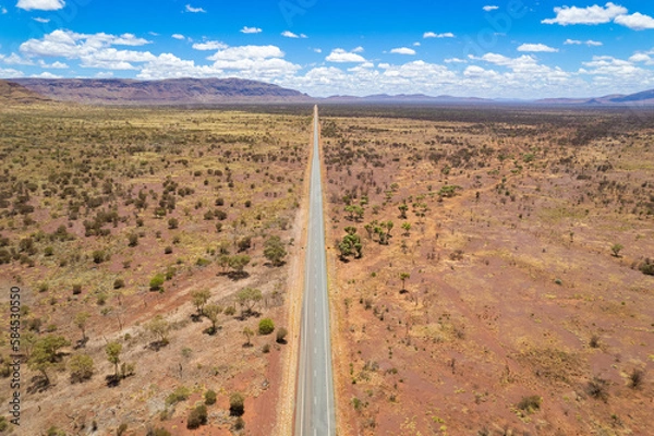 Fototapeta Aerial view of remote asphalt road that curves in the distance in the Australian outback