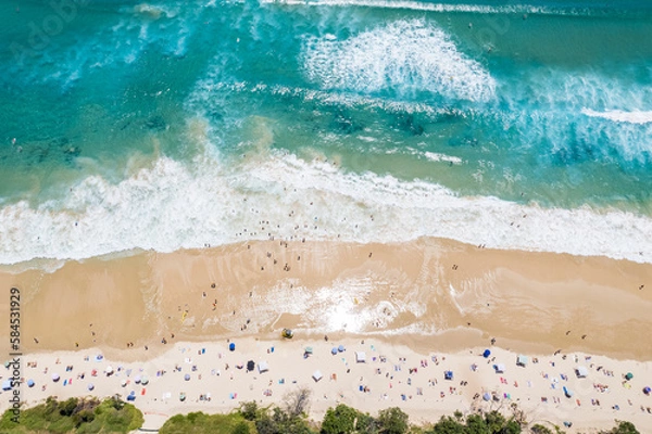 Obraz A busy beach day looking down at beach goers as the surf comes in.