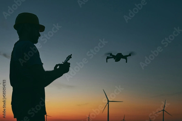 Fototapeta Engineer mechanic using drone for inspection in a windmill farm park.