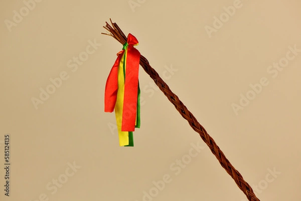 Obraz Traditional Czech Easter whip with colored ribbons 
from willow branches on the light background 