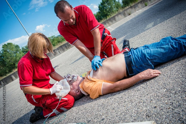 Obraz Paramedics succor a man with heart attack