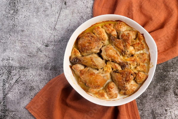 Obraz Classic Baked Chicken Pieces in a white baking dish on a dark grey background. Top view, flat lay