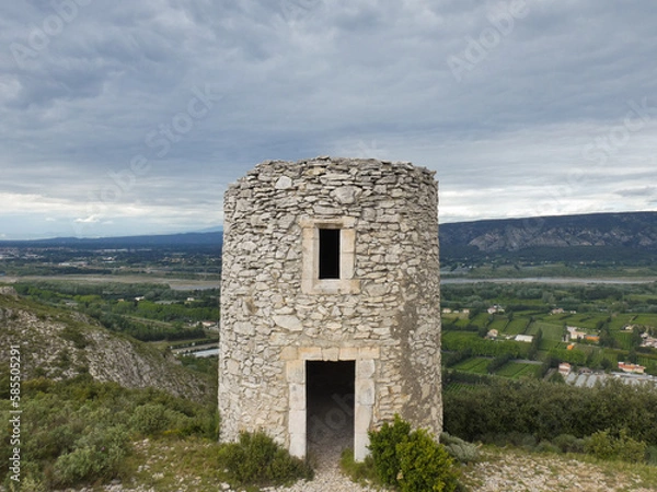 Fototapeta Chappe telegraph tower in stone at Orgon in the Alpilles with a beautiful landscape behind with the green Durance valley under a cloudy sky in Provence in France
