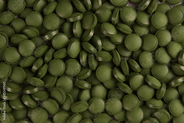 Fototapeta Green tablets of bio chlorella. A health-promoting dietary supplement rich in vitamins. Chlorella vulgaris.