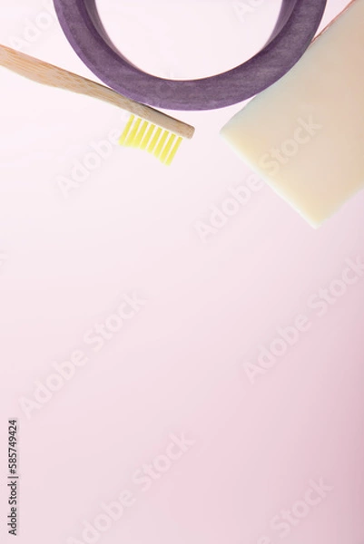 Fototapeta Composition of a bamboo toothbrush, soap and a wooden arch on a pink background. The concept of routine hygiene and personal care. Eco materials and life without plastic. Vertical photo, copy space