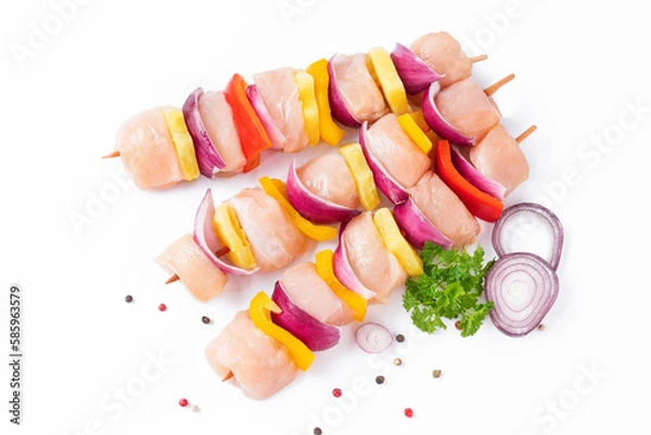 Obraz Top view.Skewers with pieces of raw meat, red, yellow and green pepper.Raw pieces of chicken skewers with pepper onion and pineapple on a white background.Uncooked mixed meat skewer with peppers.