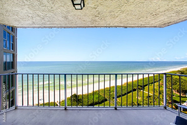 Fototapeta Balcony with Beach View Including Luscious Green Landscaping and a Building in the Foreground 