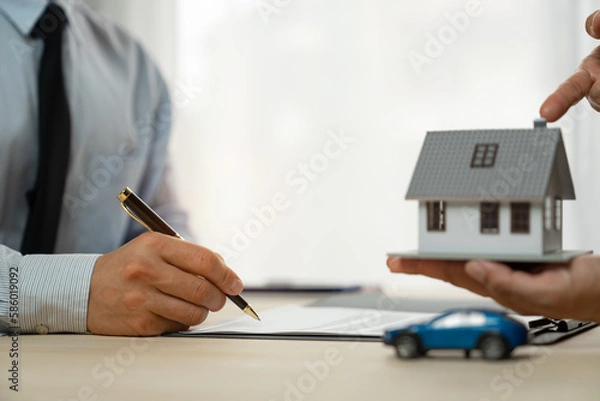 Fototapeta businessman holding a pen Sign to buy, sell or rent. Insurance takes care of real estate services. and the concept of a real estate agent offering interest in installments to their clients.