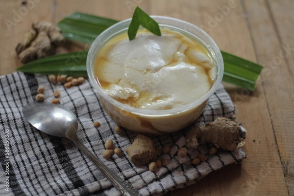 Fototapeta Wedang Tahu or Kembang Tahu, traditional dessert made of soybean pudding with palm sugar and ginger syrup
