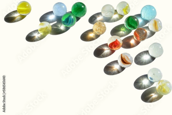 Fototapeta Grouping of marbles with bright light reflecting through various colors of glass