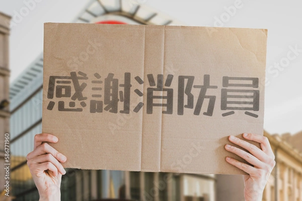 Fototapeta The phrase " Thank you firefighters " on a banner in men's hands with blurred background. Heroes. Hard job. Rescuers. Rescue. Dangerous. Respect. Honor. Support. Essential workers