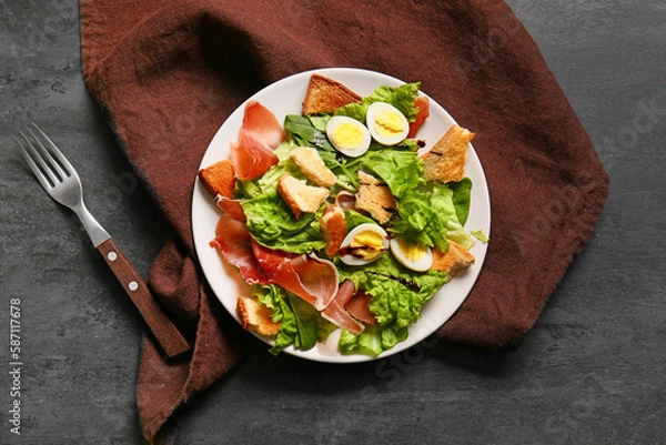 Fototapeta Plate of delicious salad with boiled eggs and jamon on black grunge background