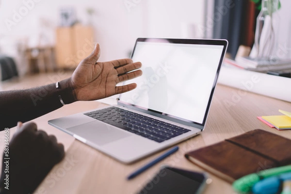 Fototapeta Crop black man showing netbook with empty screen