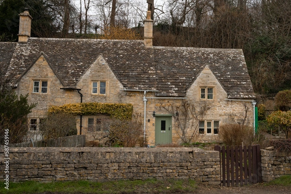 Fototapeta Iconic row of medieval stone built cottages in the picturesque village of Bibury in Cotswolds, England