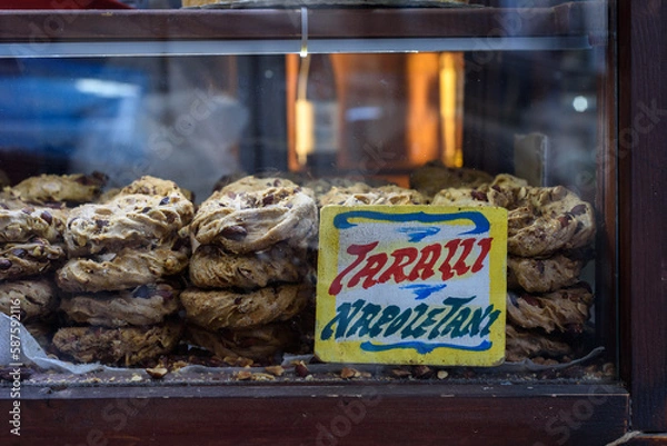 Obraz Naples, Italy. Inside a small stall with a showcase, at Via Pignasecca, the typical Neapolitan taralli with lard, pepper and almonds. A traditional tag indicates the name. 2022-08-20.