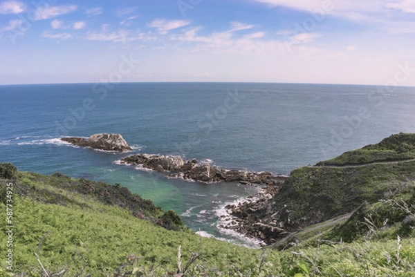 Obraz Spectacular views of the turquoise sea above a mountain with green vegetation on a summer day in Galicia. Spain