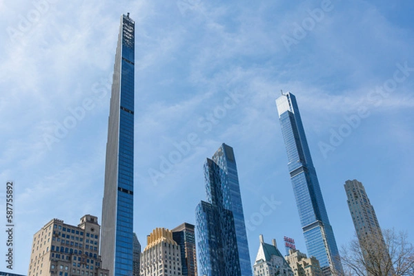 Fototapeta Steinway tower with Central park tower and other buildings at Manhattan. Low angle view from central park.