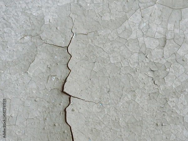 Fototapeta Peeling paint on the wall. Old concrete wall with cracked flaking paint. Weathered rough painted surface with patterns of cracks and peeling. Grunge texture for background and design. Closeup