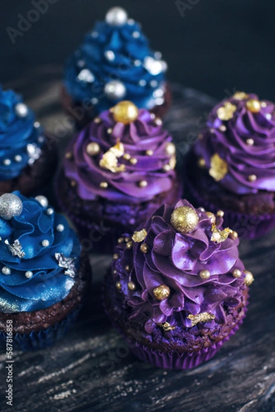 Obraz Set of chocolate cupcakes with dark blue and purple cream and golden sprinkles