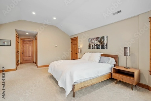 Fototapeta Beautiful contemporary rustic home interior bedroom design with a white bed and wooden doors