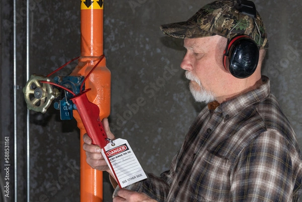 Fototapeta man applying lockout tagout on ammonia valve