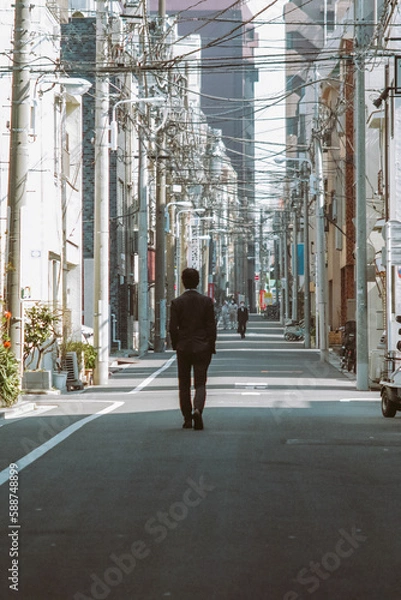 Obraz a man walks alone on the street of tokyo